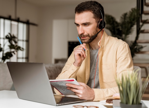 Man with headset having video call on laptop