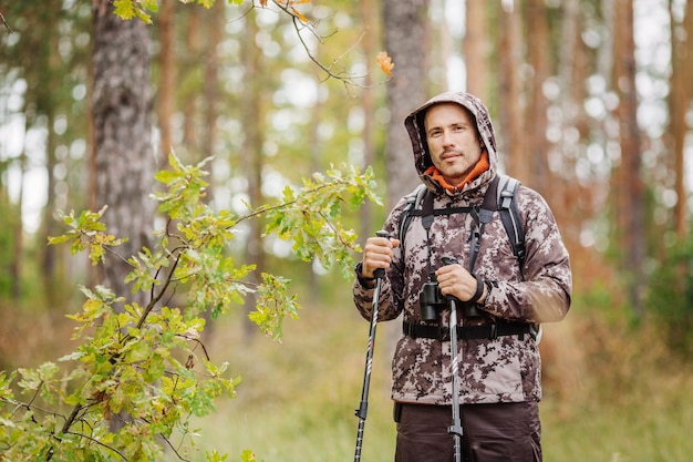 Man with hiking equipment walking in forest