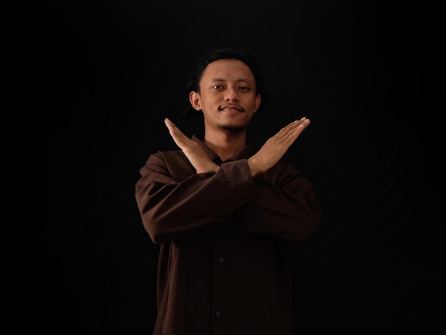 A man with his arms crossed with his arms crossed in front of a black background.