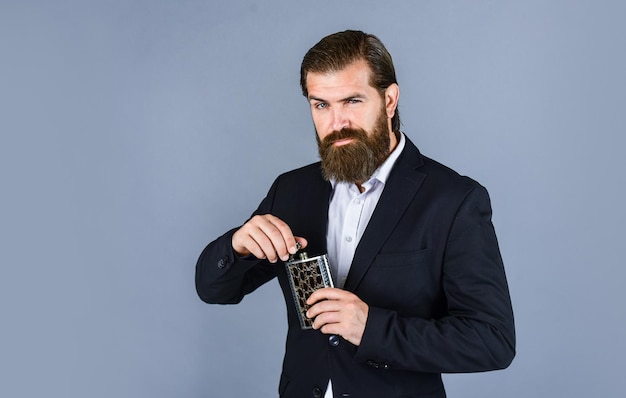 Man with his booze flask man drinks strong alcohol from iron flask while relaxing Hip flask for whiskey vintage gentleman gift shop Brutal businessman drinking alcohol copy space