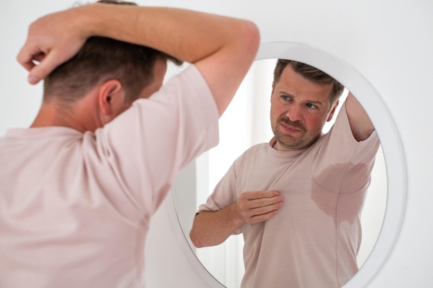 Man with hyperhidrosis sweating very badly under armpit