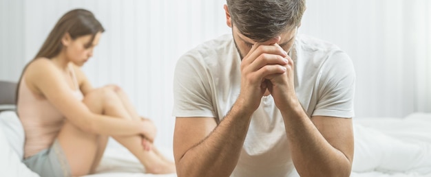 The man with impotence sit near the woman on the bed