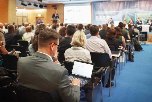 Man with laptop on large business presentation