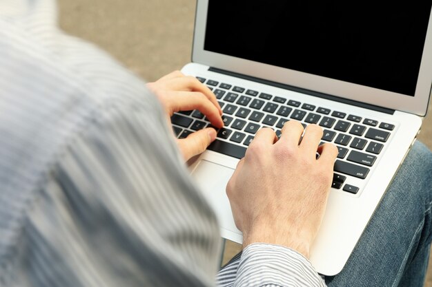 Man with laptop works in park. Outdoor work