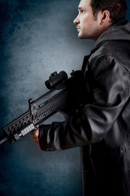 Photo man with long leather jacket and assault rifle