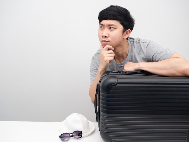 Man with luggage gesture gesture thinking with holiday looking at copy space