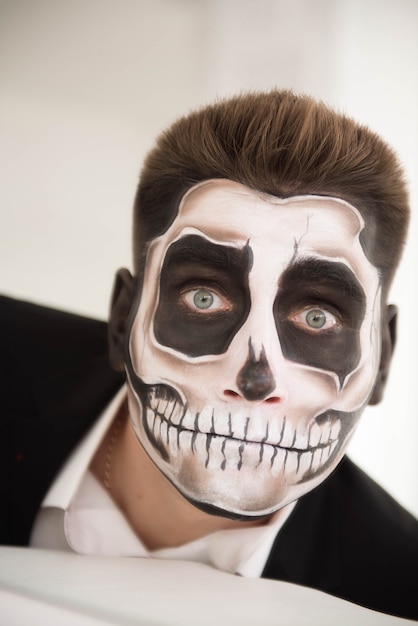 Man with make-up Halloween. Drawing a vampire, skeleton