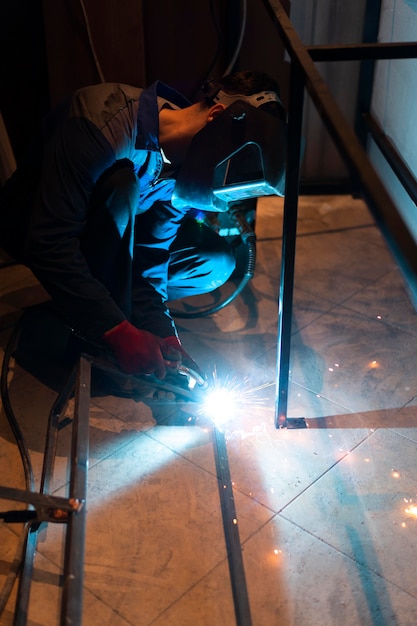 Man with mask welding metal in the atelier