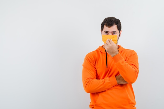 The man with medical mask is holding it on white background