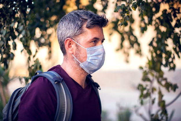 Man with medical mask outdoor. People, healthcare and medicine concept