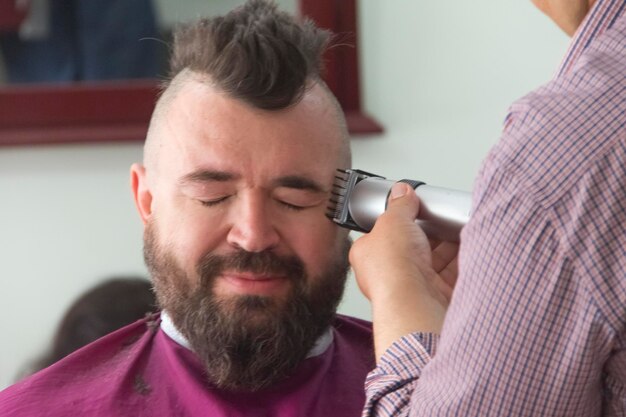 A man with a mohawk and beard in the barbershop