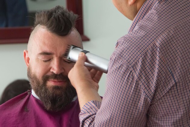 A man with a mohawk and beard in the barbershop