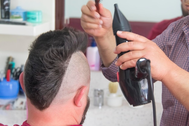 A man with a mohawk and beard in the barbershop