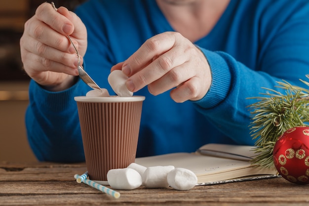 Photo man with mug hot cocoa with marshmallows, winter christmas drink