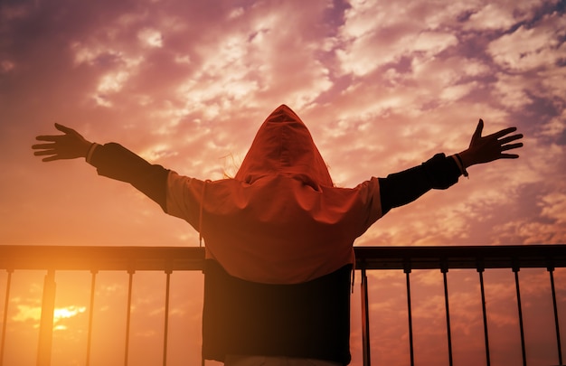 Man with open arms at sunset