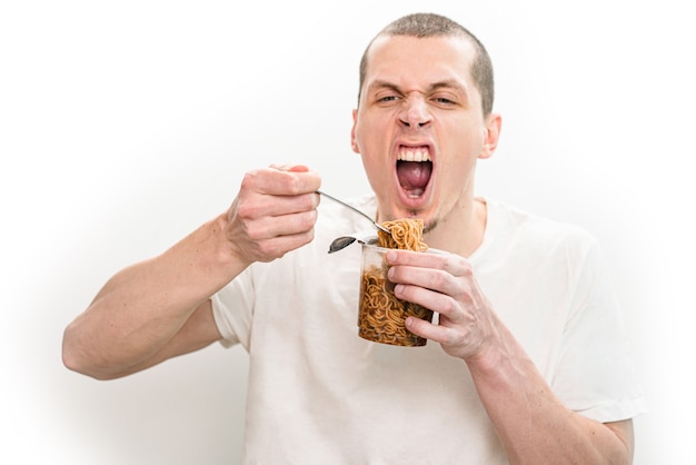 Man with open mouth emotionally eating fast food noodles from the transparent plastic cup.