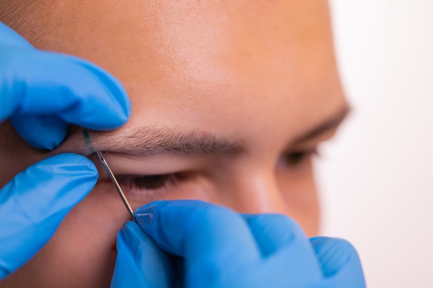 Man with pierced eyebrow three small black piercings