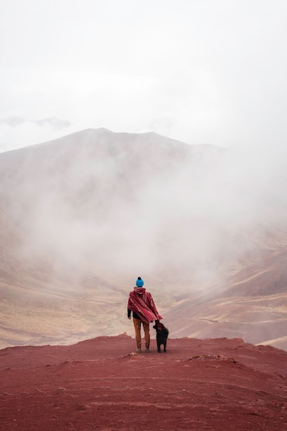 Man with poncho and dog in the Red Valley of Peru