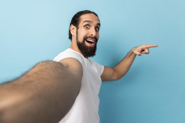 Man with positive expression pointing aside at copy space POV point of view of photo