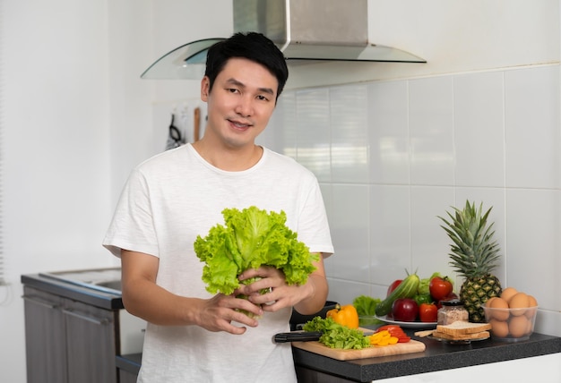 Man with preparing vegetables to cooking in the kitchen at home