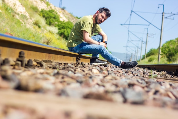 man with protective mask on railroad tracks playing on guitar