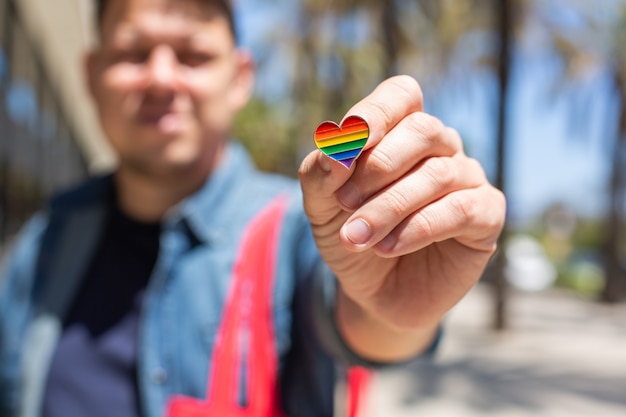 Man with rainbow reusable bag and lgbt badge pride month