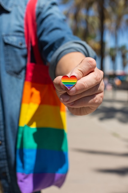 Man with rainbow reusable bag and lgbt badge pride month