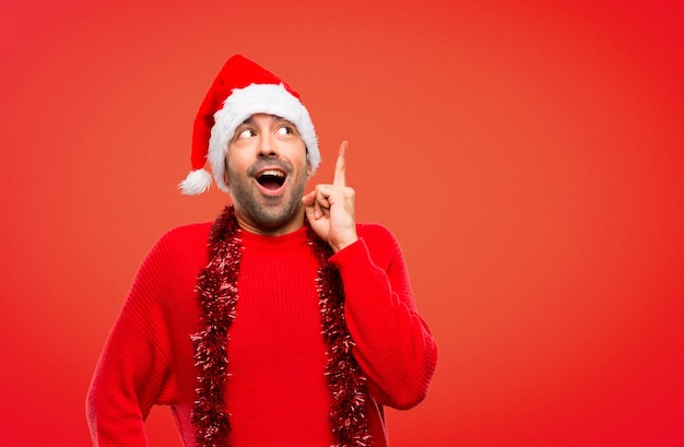 Man with red clothes celebrating the Christmas holidays standing and thinking an idea