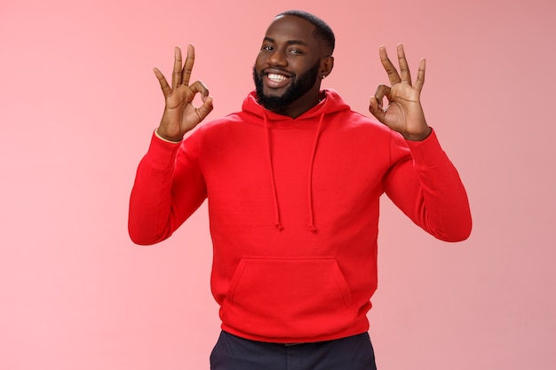 Man with a red sweatshirt over pink