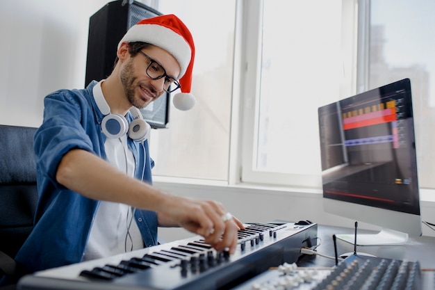 Man with Santa hat playing piano in studio