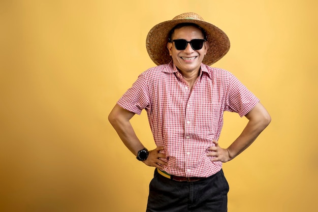 Man with a shirt wearing sunglasses and a hat standing