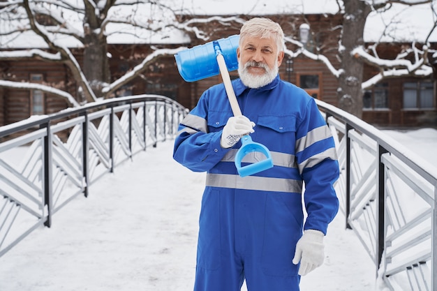 Man with shovel on shoulder in winter