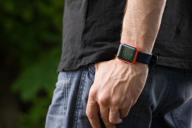 Man with smartwatch putting his hand in pocket