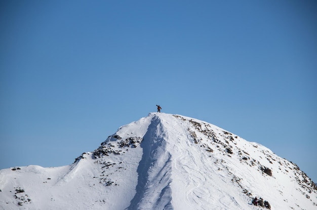 Man with snowboard at the top of the snowy Caucasian mountain