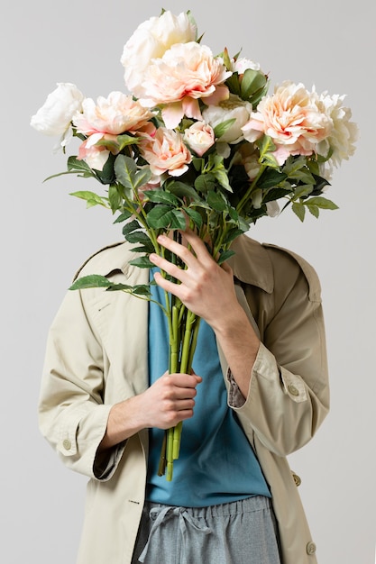 Man with trench coat holding flowers