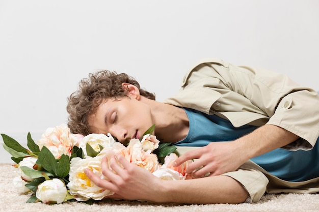 Man with trench coat holding flowers