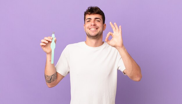 Man with a watch feeling happy, relaxed and satisfied, showing approval with okay gesture, smiling