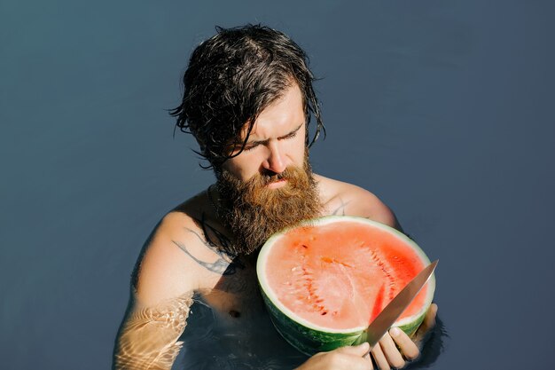 Man with watermelon and knife in pool