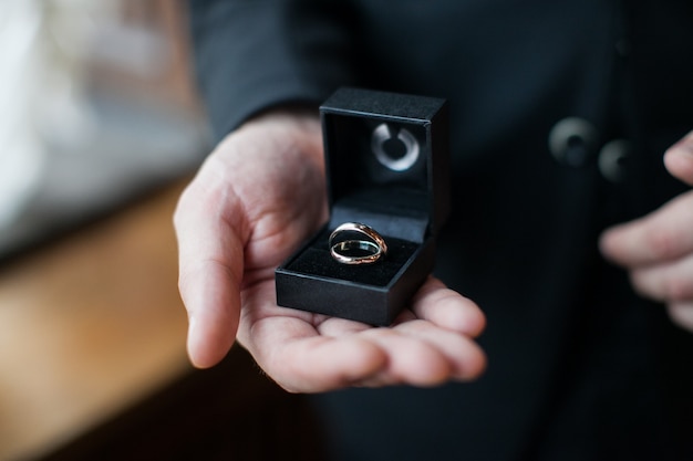 Man With A Wedding Ring. Groom Holding Gift Box With Two Rings On His Palm