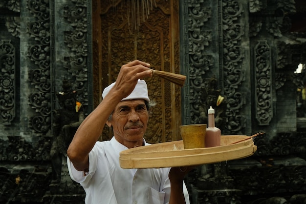 Photo a man with a white hat holding a tray with a cup on it