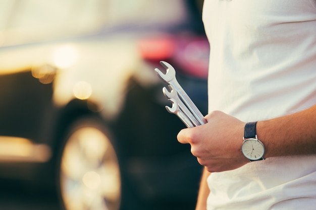 Man with wrench in hands repair car on road