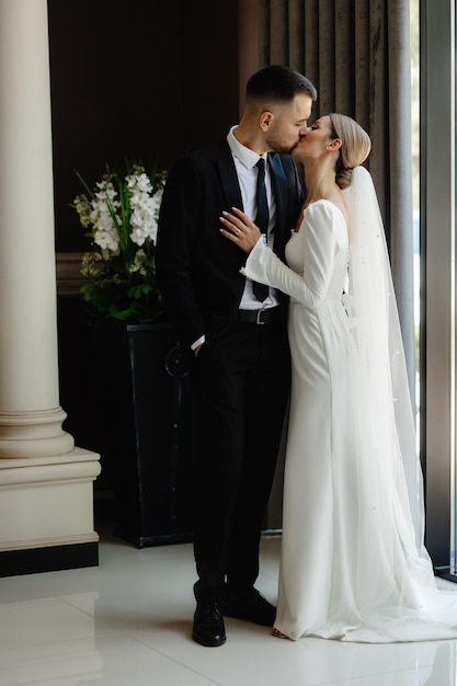 a man and woman are kissing in a building with flowers