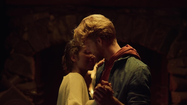 A man and woman are kissing in a dark room.