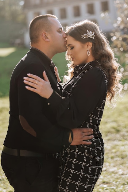 A man and woman are kissing in a park