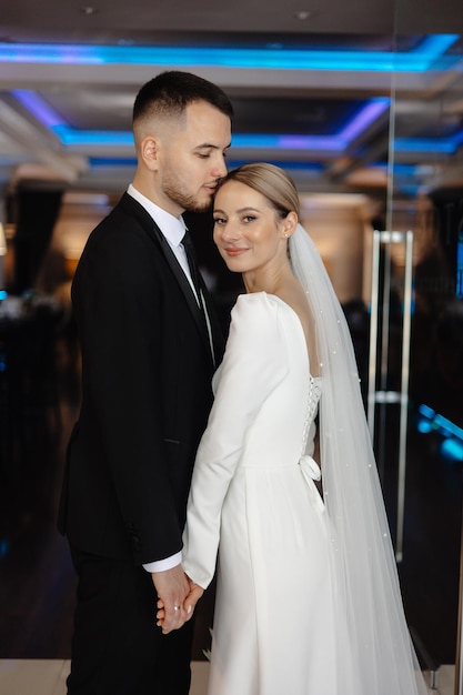 a man and woman are posing for a photo in front of a window