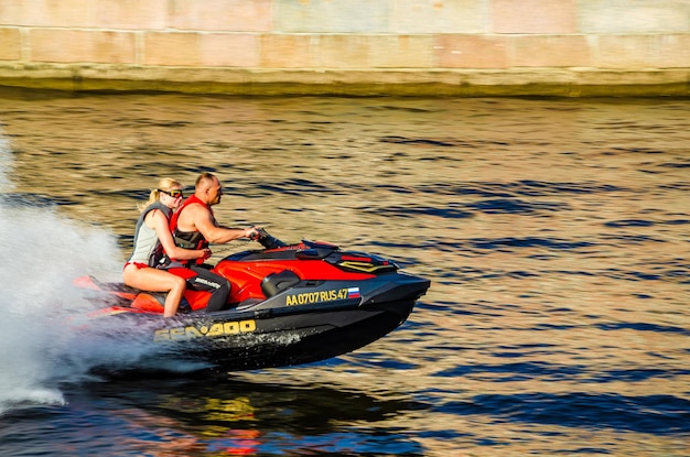 A man and a woman are riding a jet ski in the water.