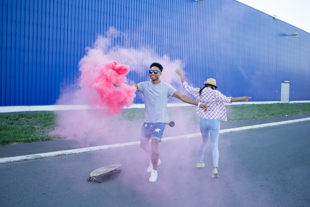 a man and woman are running in front of a wall with smoke coming out of them