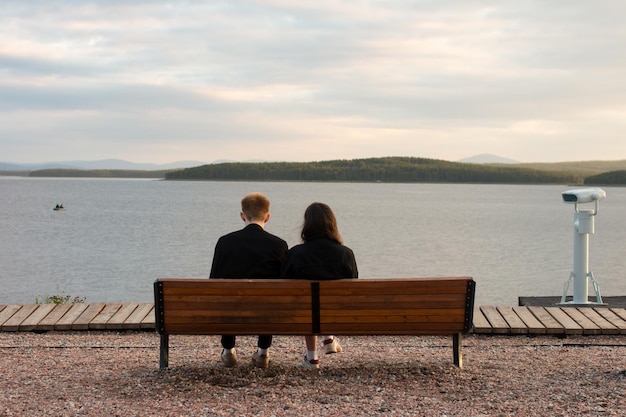 A man and a woman are sitting on a bench on the sea embankment Rest