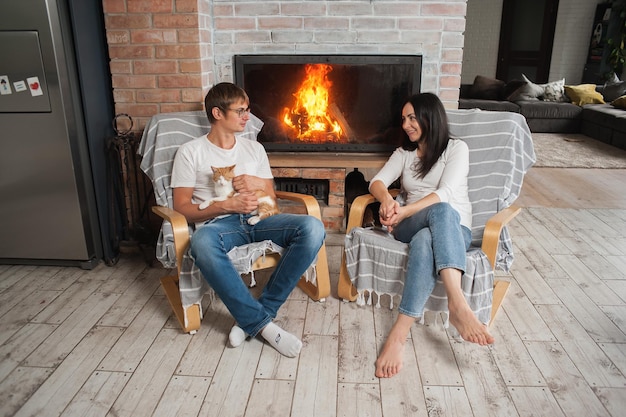 A man and a woman are sitting near the fireplace Romantic evening