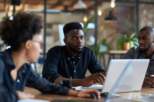 a man and a woman are sitting at a table with laptops and one of them has a man on the left